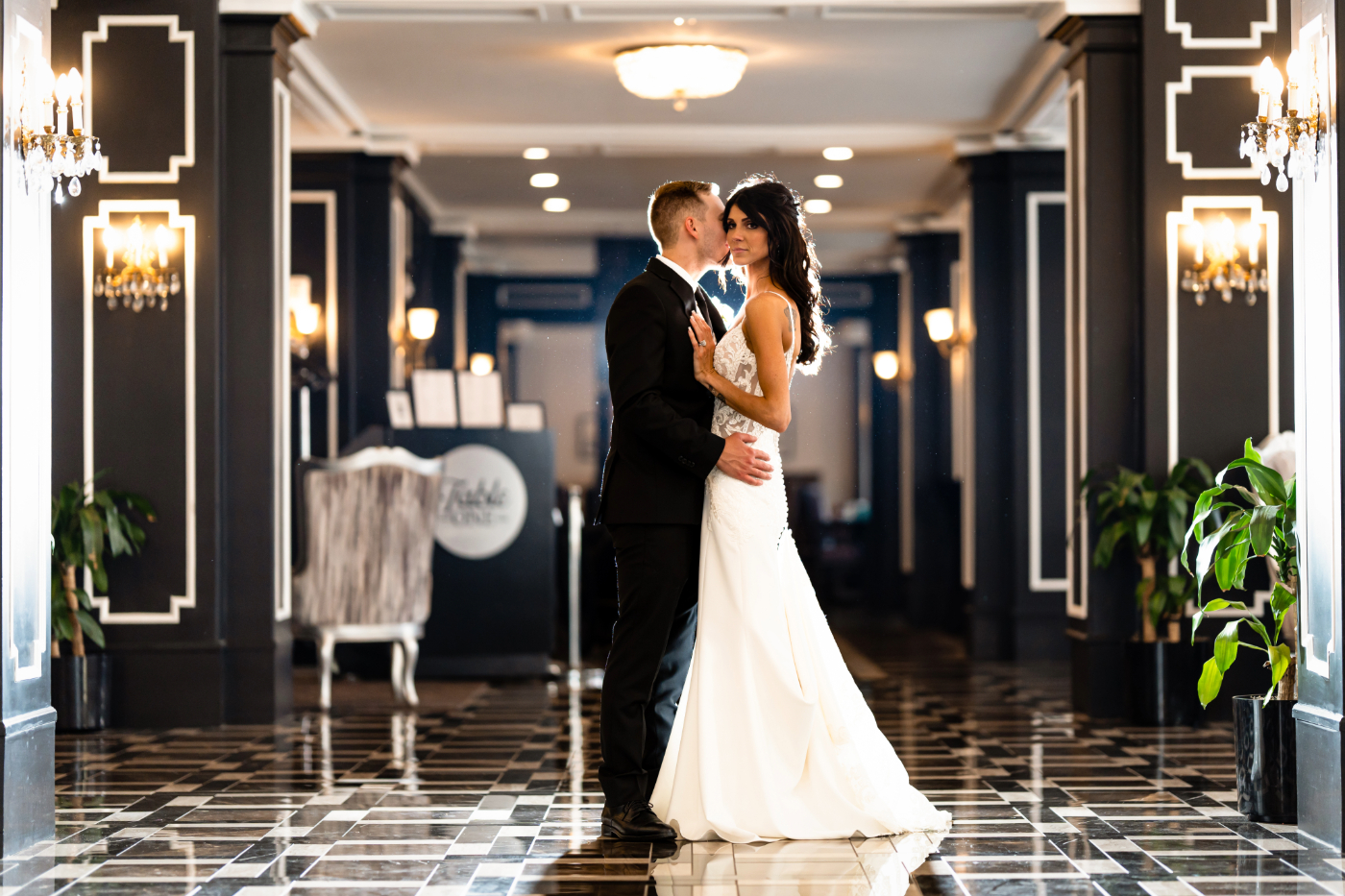 Bride and groom share a romantic moment in the elegant lobby of Hotel Retlaw in Fond Du Lac, Wisconsin, captured by a Fond Du Lac wedding photographer