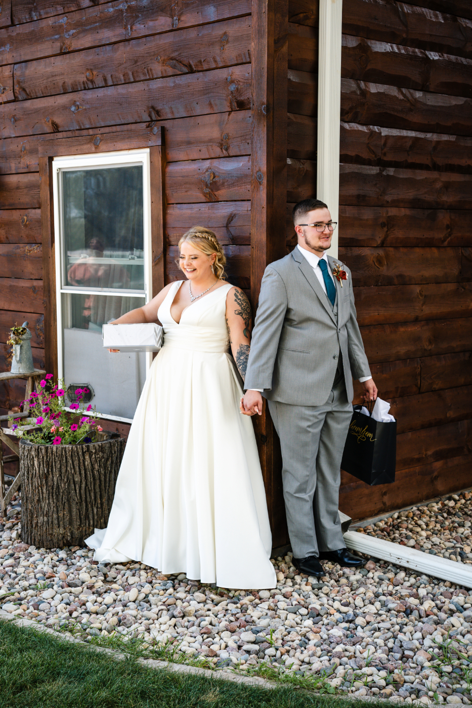 Bride and groom exchange gifts while standing around the corner from each other before their wedding ceremony in at the Poplar Creek Barn before their ceremony in Oshkosh, Wisconsin, without seeing each other, captured by an Oshkosh wedding photographer