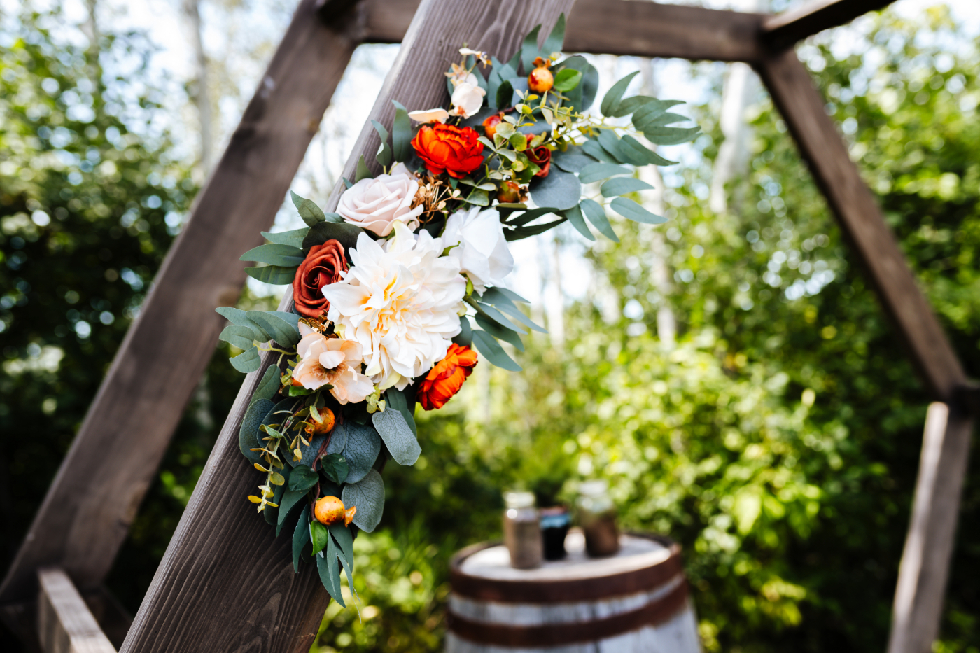 Floral arrangement on the ceremony arch at the outdoor portion of Poplar Creek venue in Oshkosh, beautifully captured by a wedding photographer specializing in local weddings